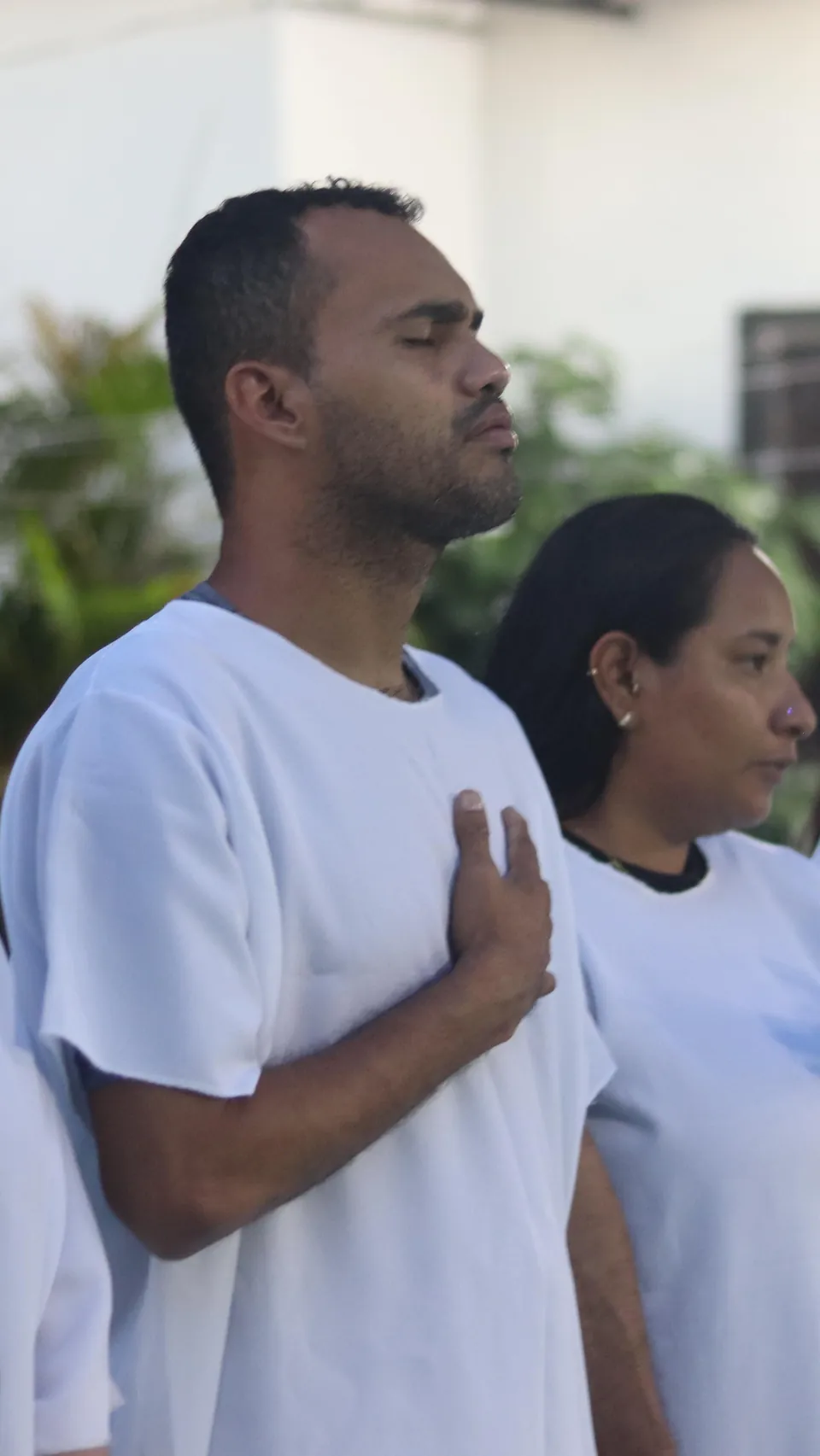 Homens da MUP orando com a mão no peito